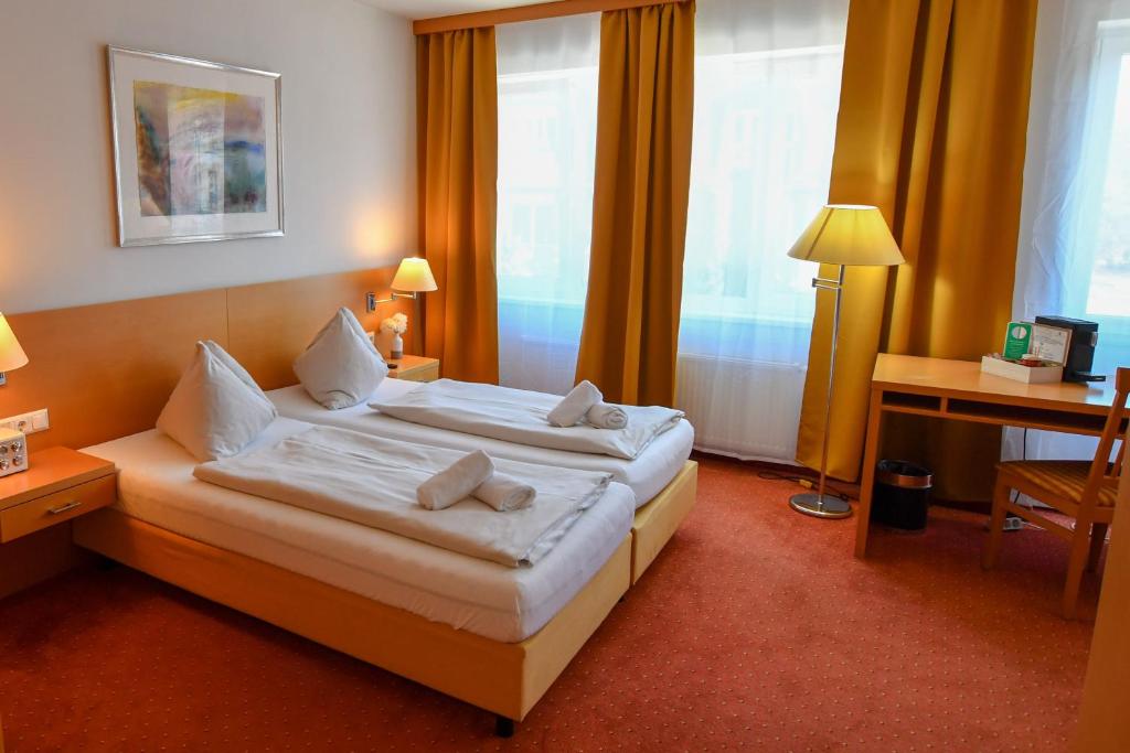 菲拉赫Motel55 - nettes Hotel mit Self Check-In in Villach, Warmbad的酒店客房配有两张床和一张书桌