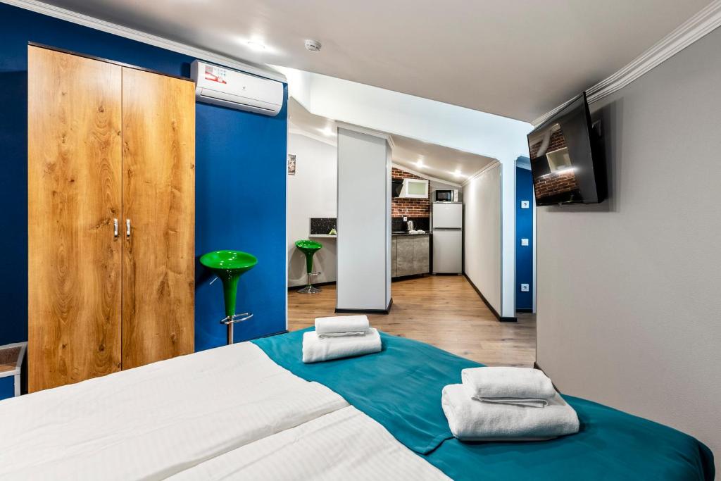 莫斯科Апарт-отель "Loftet Apartments"的一间拥有蓝色墙壁的卧室和一张带毛巾的床