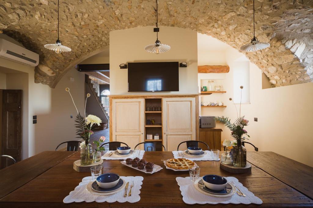 纳托Corte Mira的一间带木桌和电视的用餐室