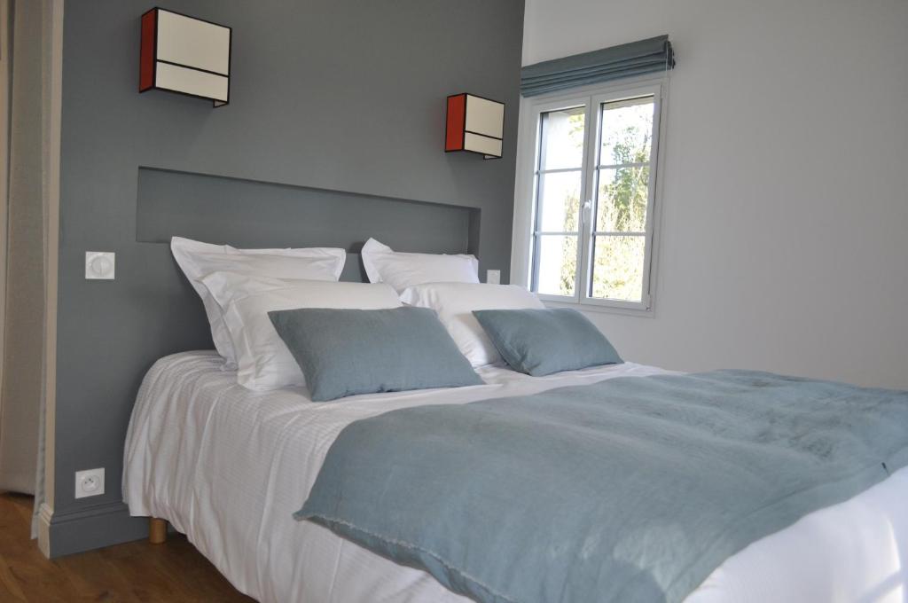 阿拉东Ti Laouen Chambres d'hôtes et gite的一间卧室配有一张带白色和蓝色床单的大床