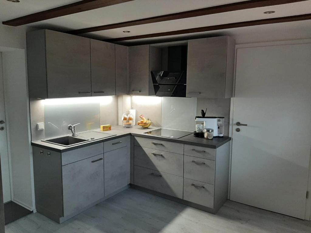施马尔卡尔登Ferienhaus Schmalkalden的厨房配有白色橱柜和水槽