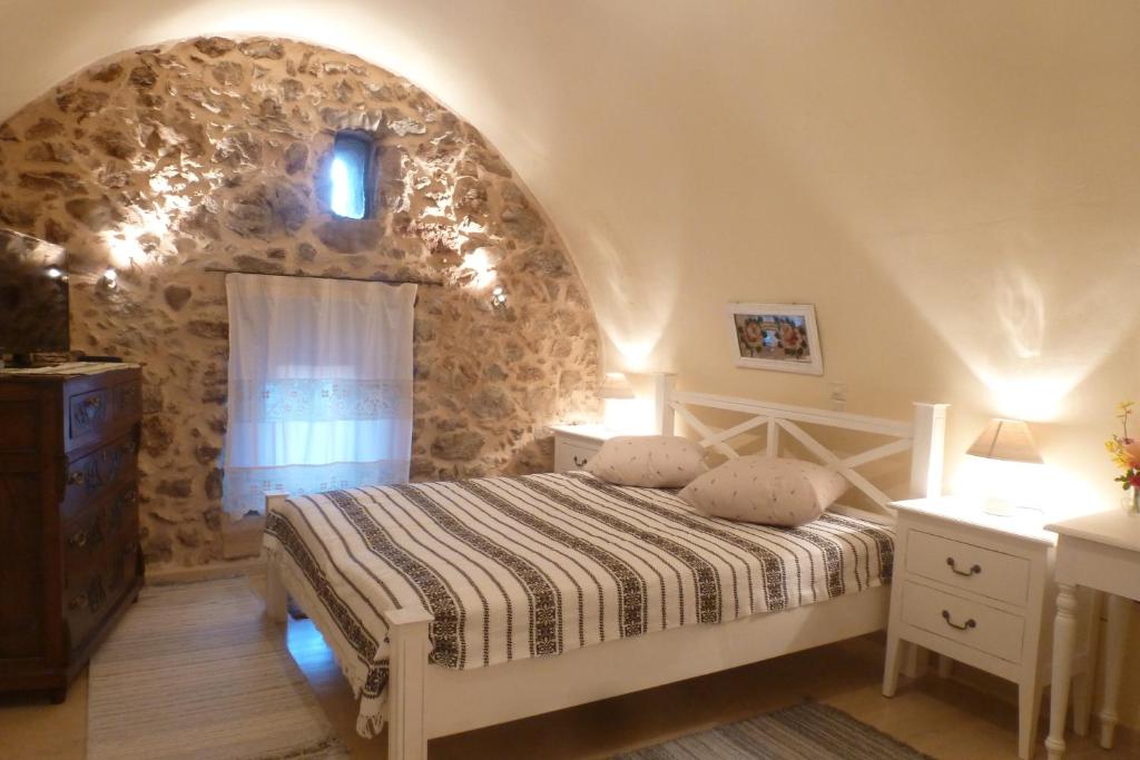AvgonymaTo Petradi的一间卧室设有一张床和石墙