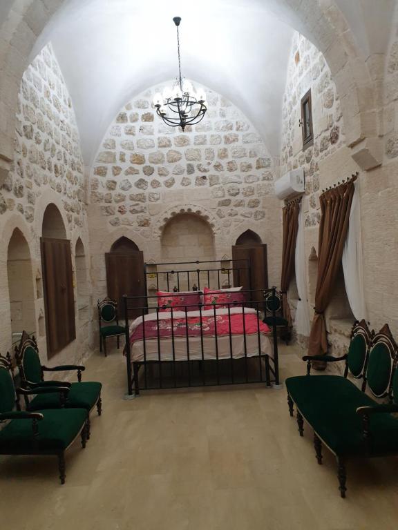马尔丁Mardin tarihi ulu Cami yanı, tarihi Konak的一间卧室,卧室内配有一张床和椅子