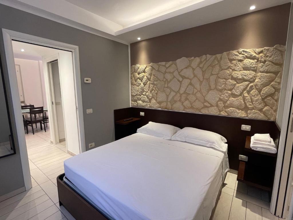 安科纳Al Piano 2的一间卧室设有一张带石墙的大床