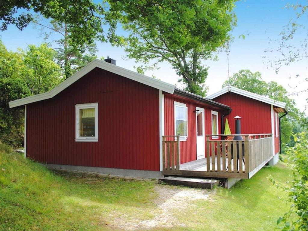 Henån4 person holiday home in HEN N的红色的房子,设有门廊和甲板