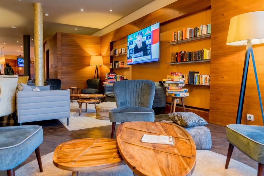 本斯海姆巴克斯酒店的客厅配有椅子和电视