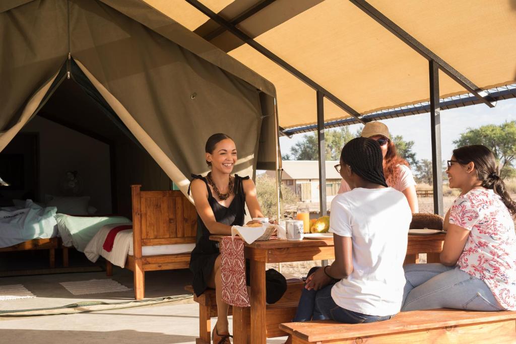 索利泰尔Namib Desert Camping2Go的一群人坐在帐篷里的桌子上