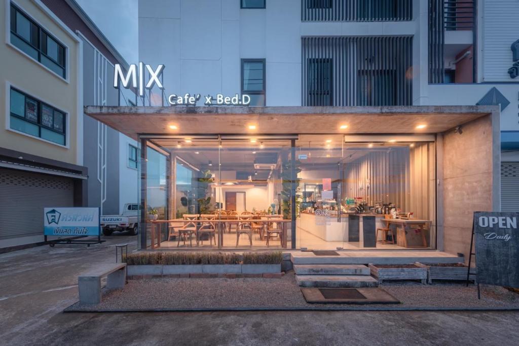 美索Mix cafe x Bed D的一座带用餐区和桌子的建筑