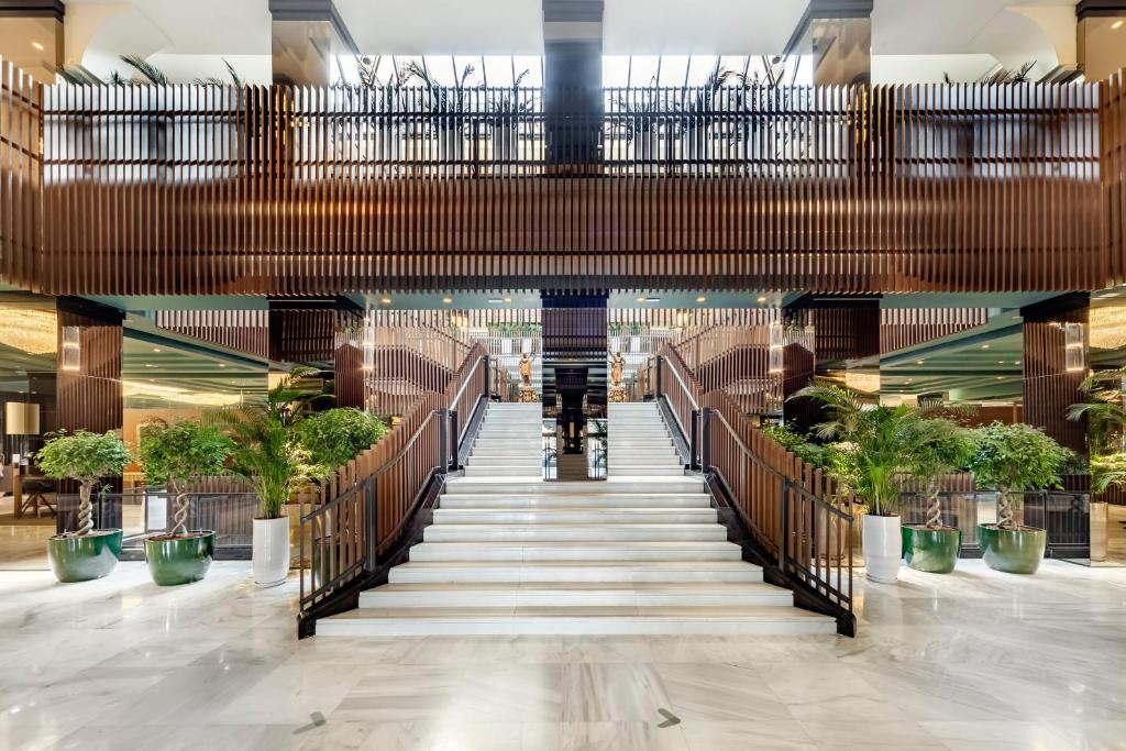 米兰米兰美利亚酒店的建筑里带楼梯和植物的走廊