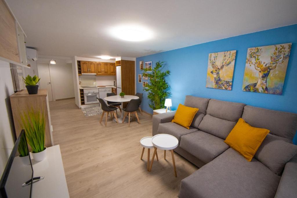 阿尔卡尼斯MEQUEDO PLAZA SAN FRANCISCO的客厅配有灰色的沙发和黄色的枕头。