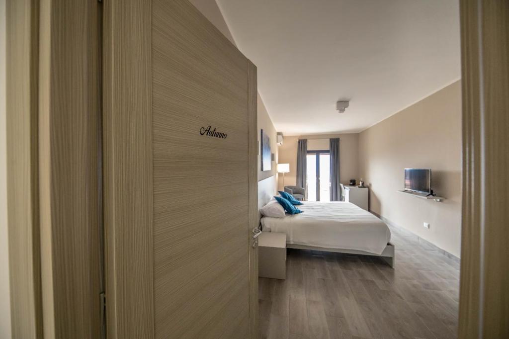 卡坦扎罗Il Gelso Guest House的一间卧室配有一张床,一扇门通往房间