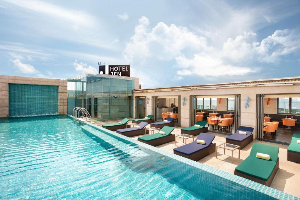 马累Jen Maldives Male by Shangri-La的酒店游泳池设有躺椅和餐厅