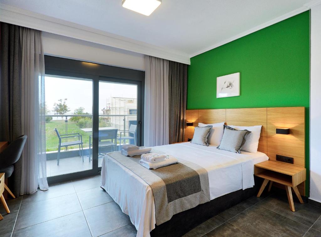 新马尔马拉斯Botanica Luxury Suites的一间卧室设有一张大床和绿色的墙壁