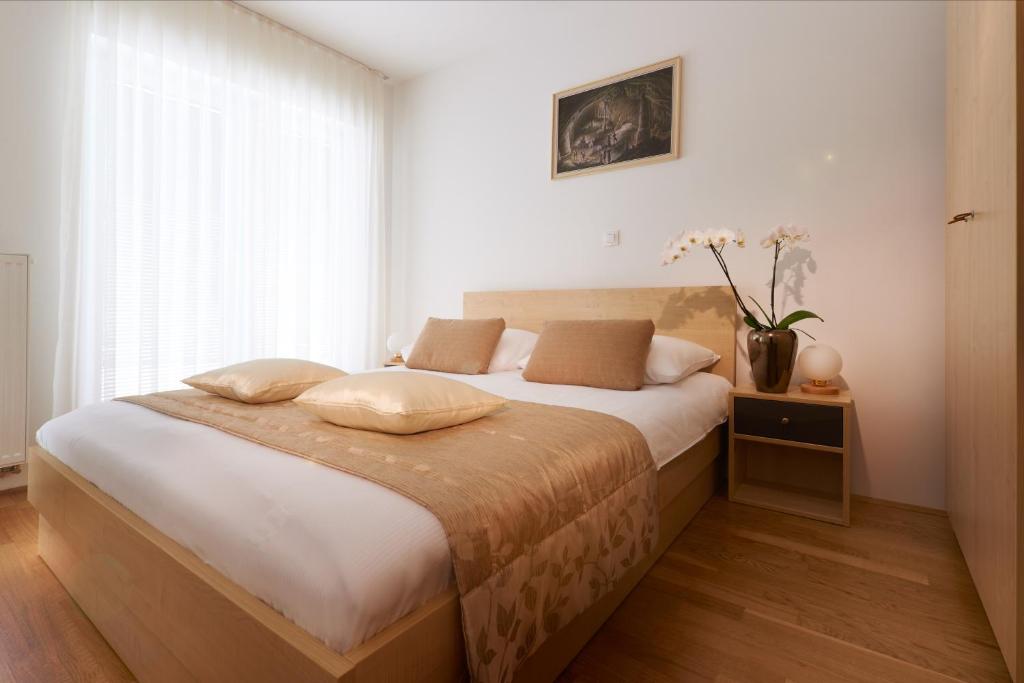 波斯托伊纳波斯托伊纳海神洞穴客房及公寓酒店的一间卧室配有床和花瓶