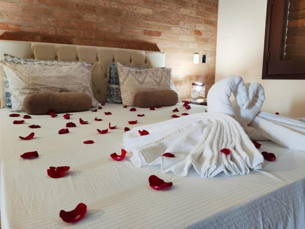 库尼亚Casarão com piscina e cachoeira CUNHA SP的一张床上有红色玫瑰花瓣的床