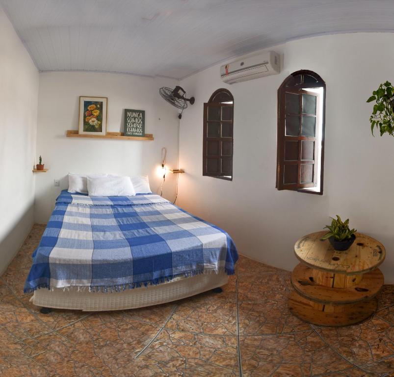 萨尔瓦多Puleiro Hostel的卧室配有蓝色和白色的床和一张桌子