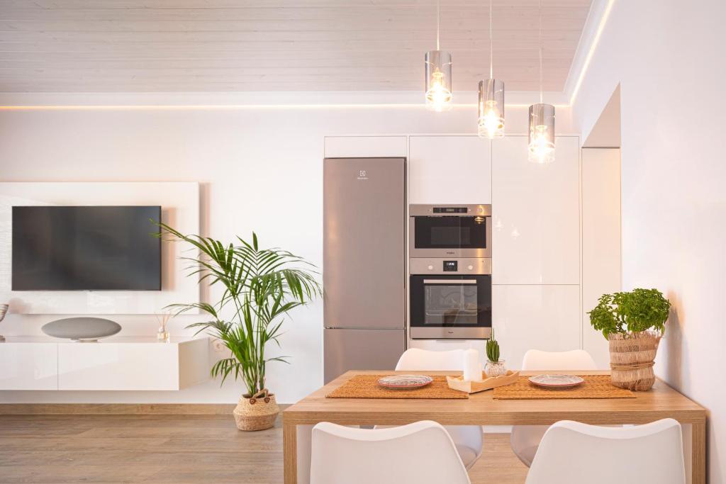伊莱恩ETHOS Luxury Home - Seaview Villa with Hot-Tub!的厨房配有带白色椅子的木桌