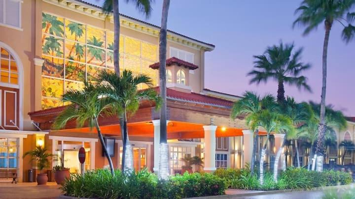 棕榈滩拉卡班纳旅游BRC一室公寓套房酒店的一座棕榈树环绕的大建筑