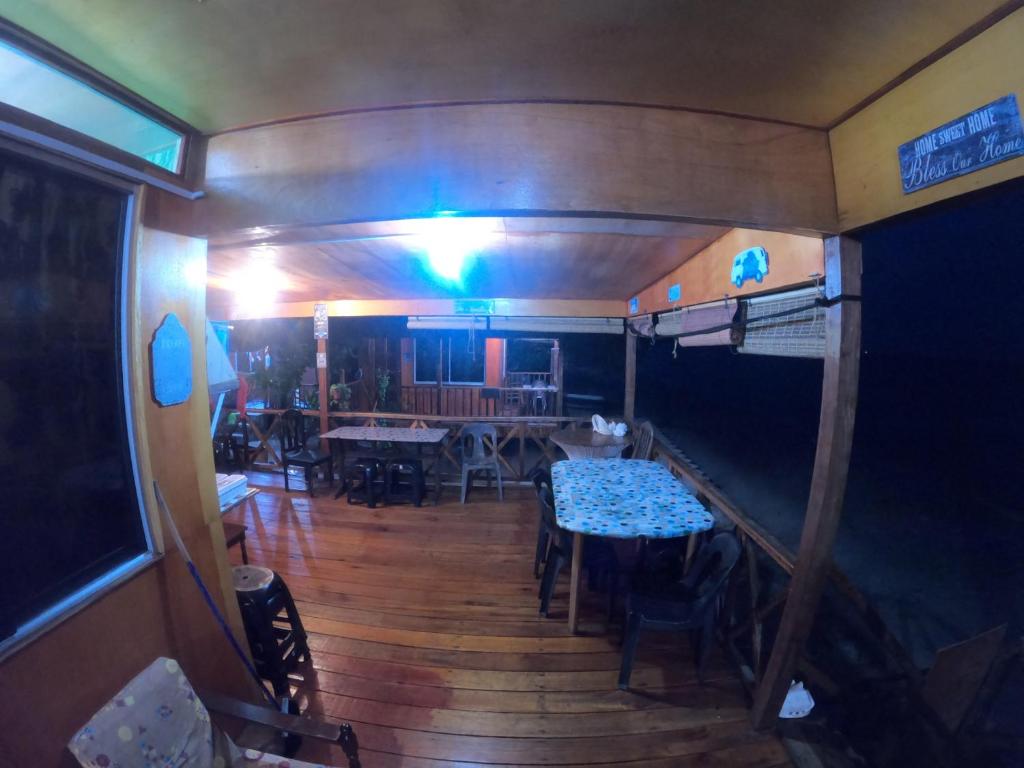 古达Tajau Laut Guesthouse的一间在拖车上配有桌椅的用餐室