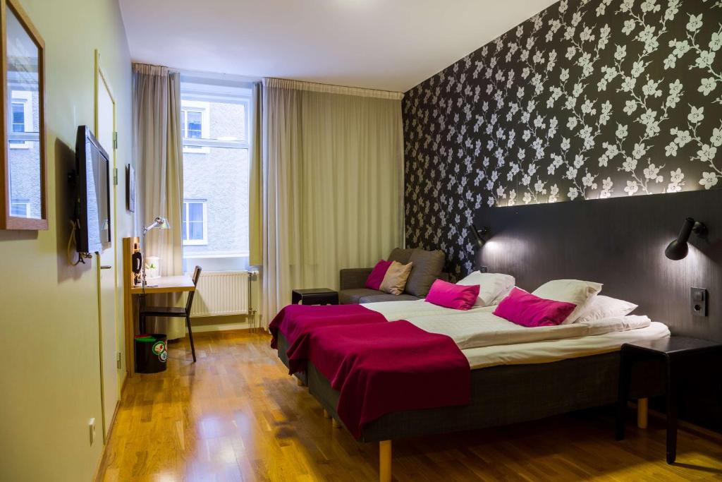 舍夫德斯堪迪克比尔灵根酒店的卧室配有一张带粉红色枕头的大床