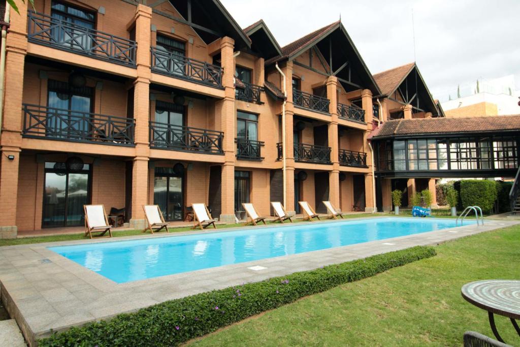塔那那利佛Radisson Hotel Tamboho Waterfront Antananarivo的大楼前设有游泳池的酒店