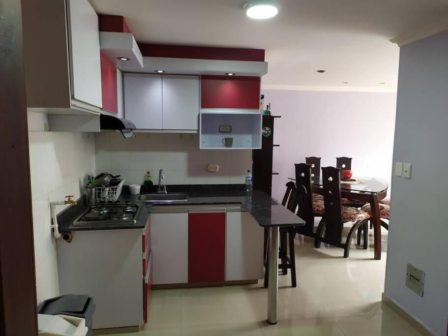 帕斯托Hermoso apartamento en Pasto. Central parque San Andrés的厨房配有红色和白色的橱柜和桌子