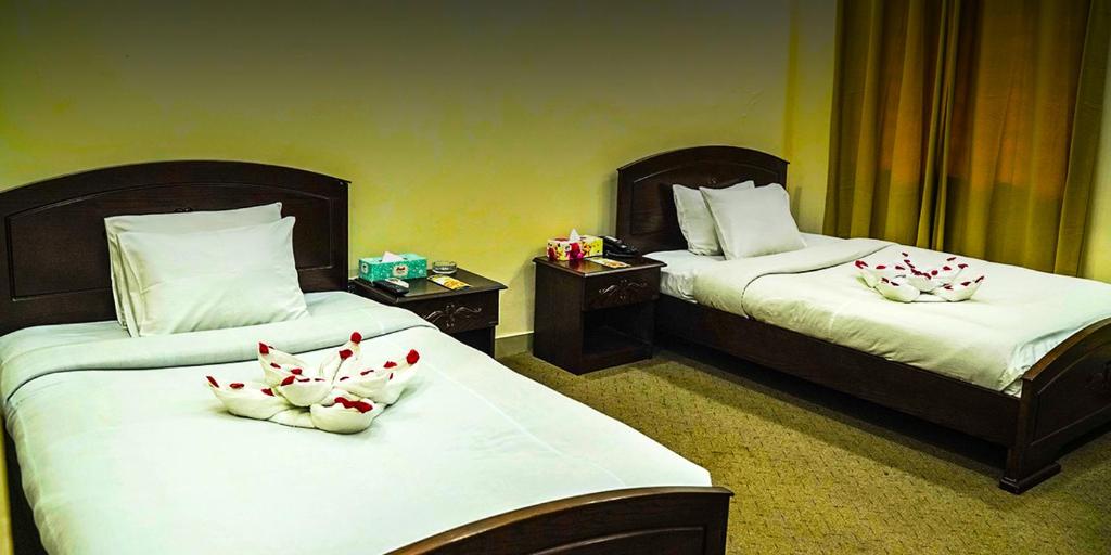 Lakshmanpur BālāpāraEque Heritage Hotel & Resort的酒店客房,配有两张带鲜花的床