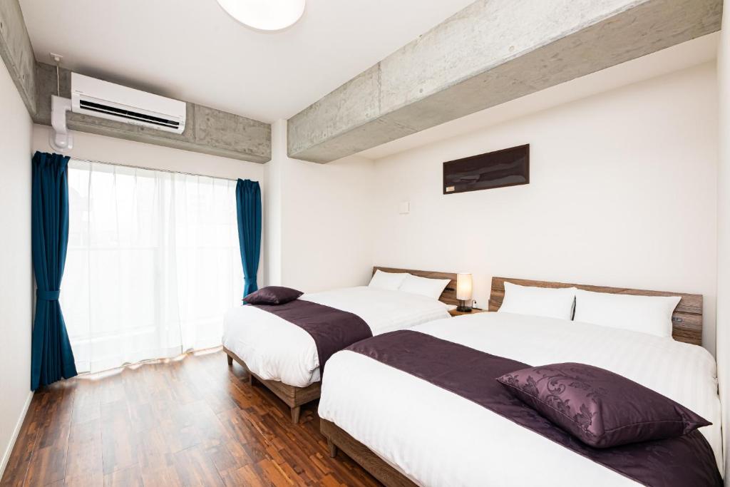 鹿儿岛STAYTUS - Vacation STAY 62201v的一间卧室设有两张床和窗户。