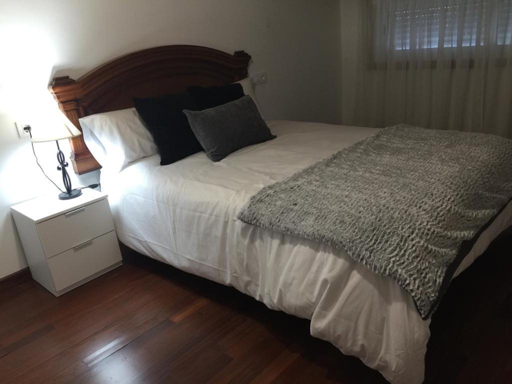 维戈Casa compartida的一间卧室配有一张大床、床头柜和一张四柱床