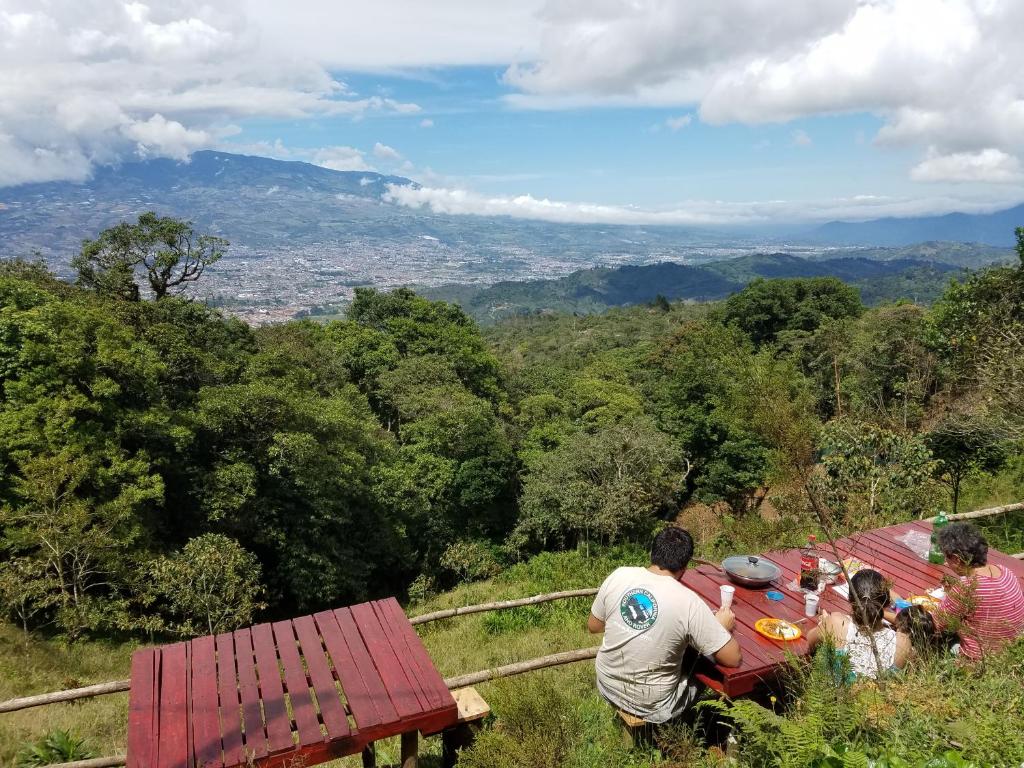 San IsidroEscapadita al Bosque的一群坐在山坡上桌子上的人