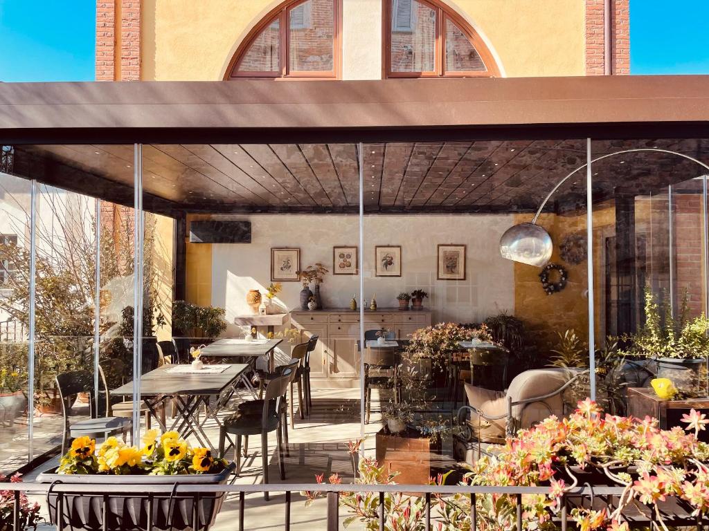 伊夫雷亚斯帕齐奥[比安科]酒店的户外庭院设有桌椅和鲜花