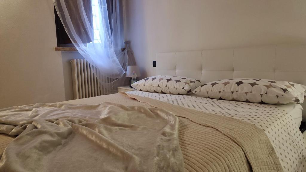 曼托瓦Ca' degli Sposi的一间卧室配有两张带枕头的床和窗户。