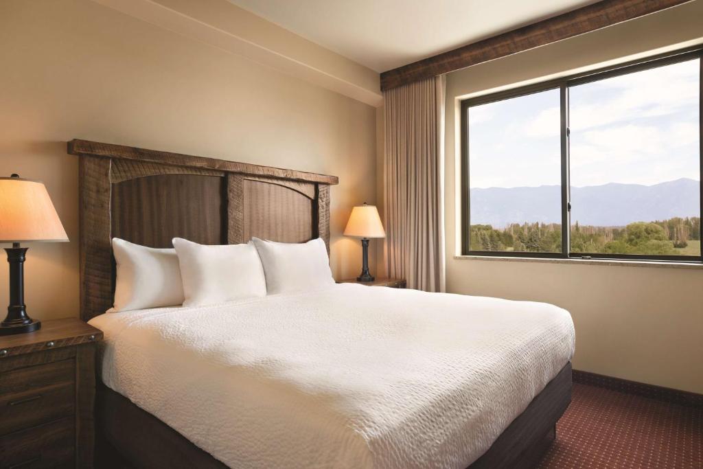 卡利斯佩尔Glacier International Lodge的一间卧室设有一张床和一个大窗户