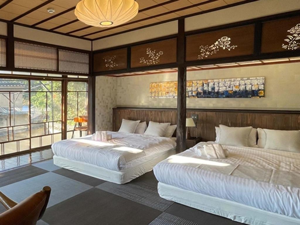 廿日市KIYOMORI的带窗户的客房内的两张床