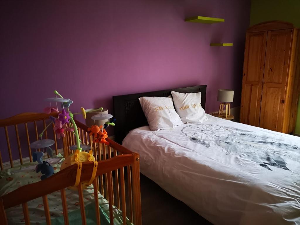 ClairvauxMaison familiale de l Abbaye的一间卧室配有一张床和紫色的墙壁