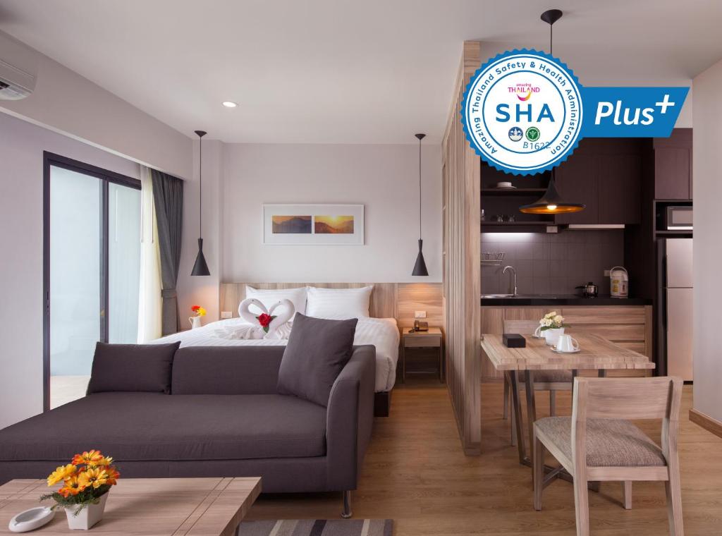 Si Maha Phot运河304公寓式酒店的酒店客房配有床、沙发和桌子。