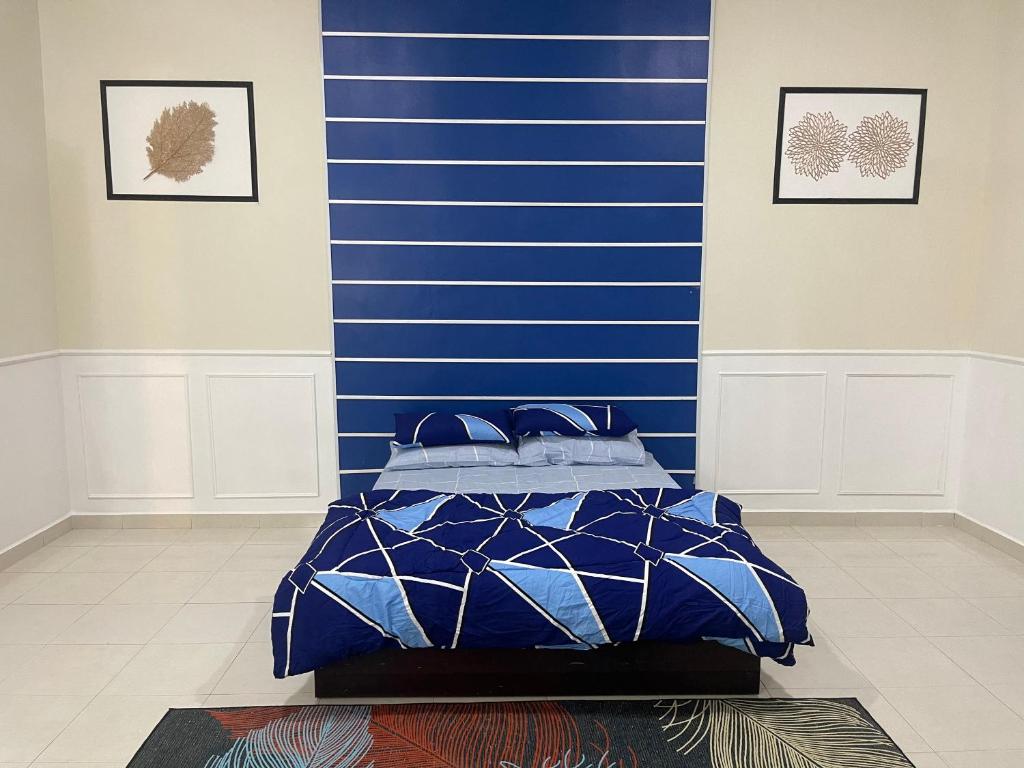 卢穆特No 61 Nazirin Homestay Tmn Indah Raya 2 Manjung Lumut的蓝色墙壁间的一张床位