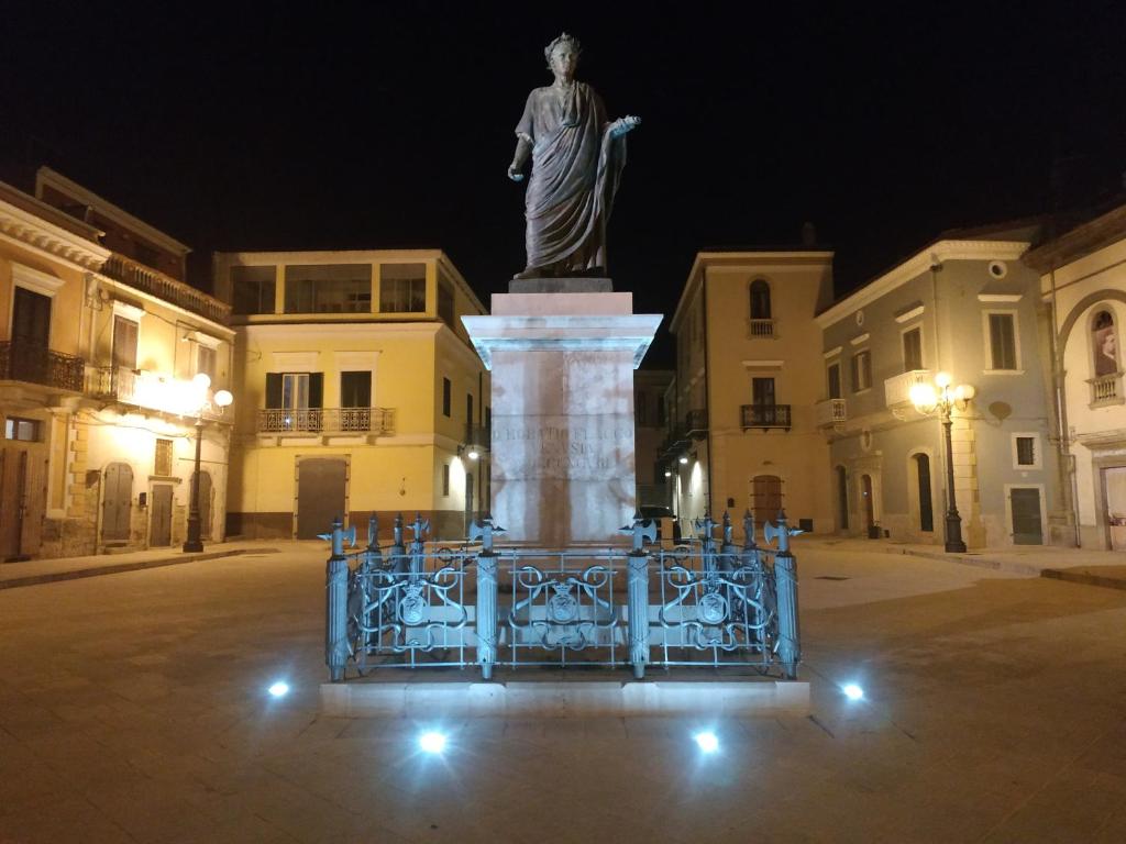 韦诺萨Bed and Breakfast In Piazza Orazio的夜中街道上的雕像