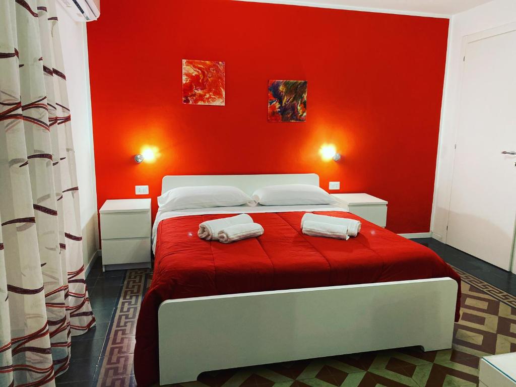 卡塔尼亚Antica Dimora Maravigna的红色卧室配有带2条毛巾的床