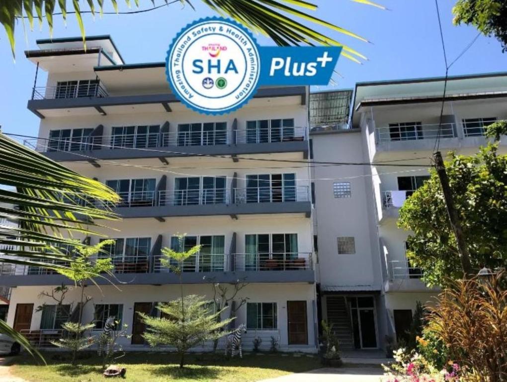 卡伦海滩Kasemsuk Guesthouse SHA Extra plus的带有读Shka+的标志的建筑