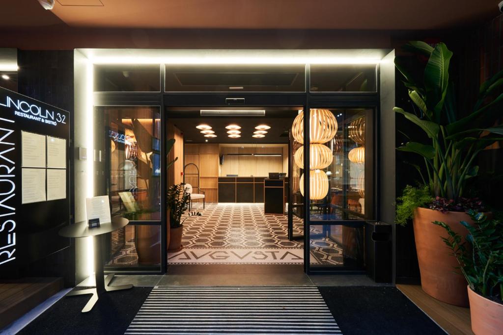 巴塞罗那奥古斯塔公寓式酒店的一座建筑的入口,大堂种植了植物