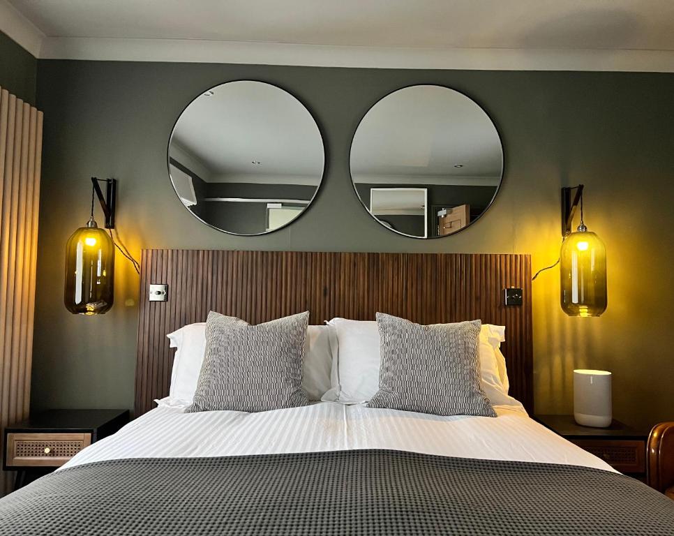 塔维斯托克Rockmount Rooms & Apartment的卧室配有一张大床,墙上挂有两面镜子