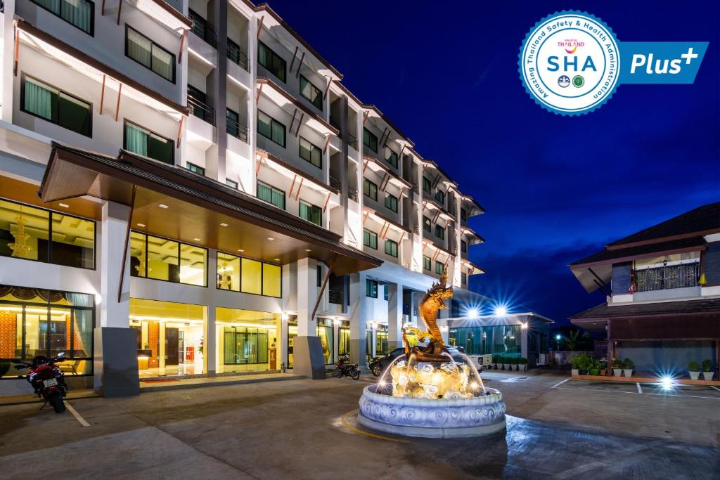 洛坤府Pura Nakhon Hotel的一座建筑前有喷泉的酒店