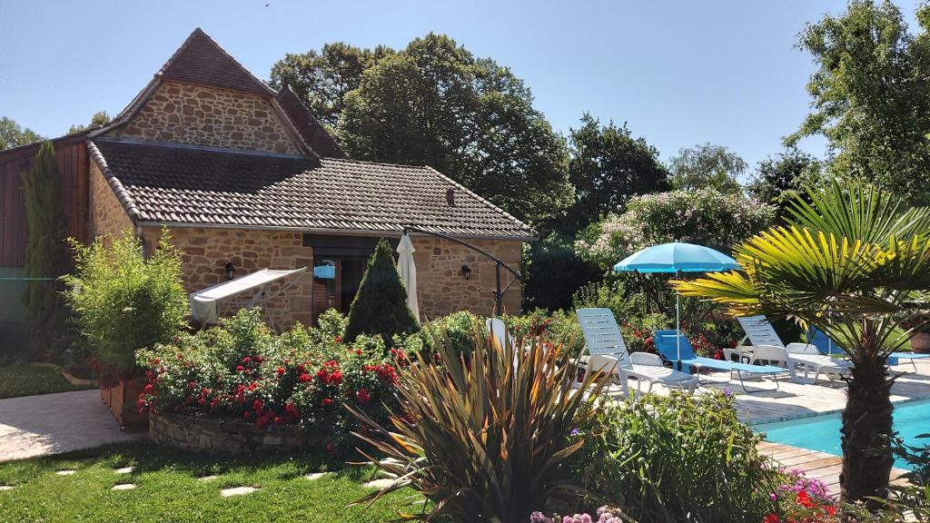 拉卡佩勒-马里瓦勒LE POULAILLER DE LA CHAYRIE的一个带游泳池、椅子和房子的花园
