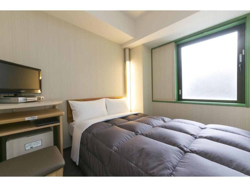 札幌R&B Hotel Sapporo Kita 3 Nishi 2 - Vacation STAY 39508v的配有一张床和一台平面电视的酒店客房