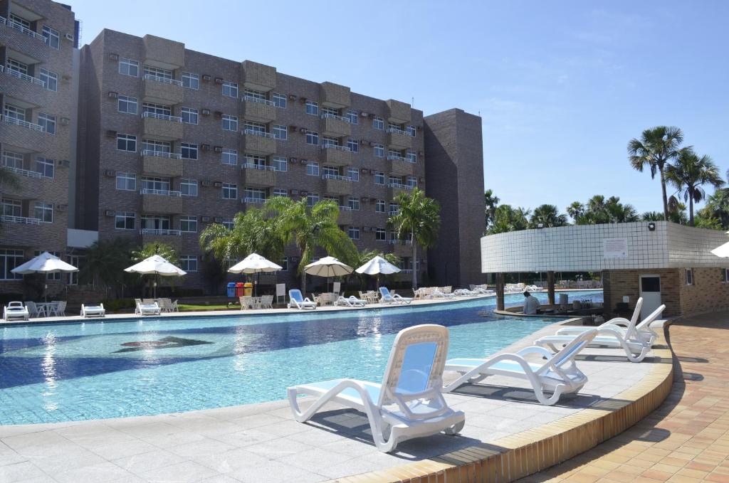 巴雷里尼亚斯Quarto em Gran Lençóis Flat Residence的一个带躺椅的游泳池和一间酒店