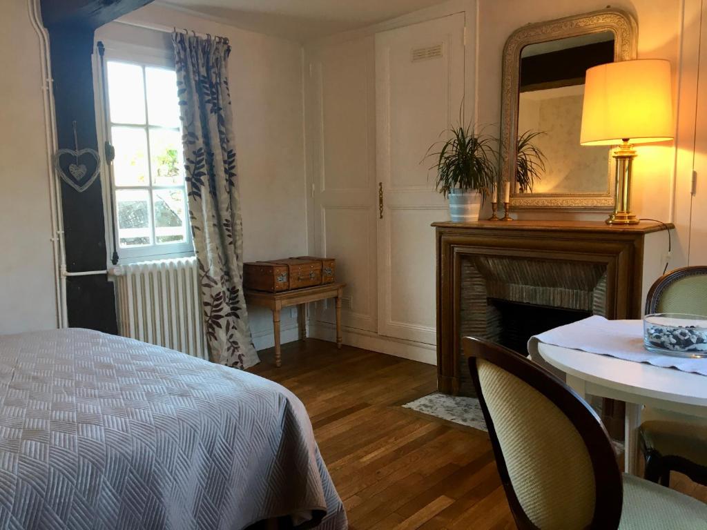 弗农La petite duchesse的一间卧室配有一张床、一张桌子和一面镜子