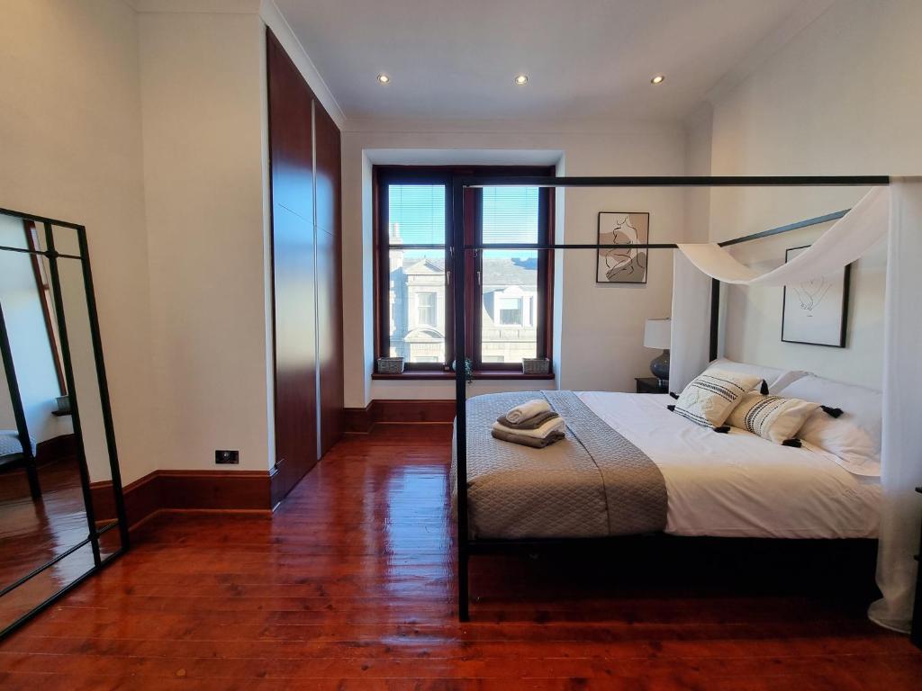 阿伯丁Luxury 2 bedroom city centre apartment with panoramic views and high ceilings的一间卧室设有一张床和一个大窗户