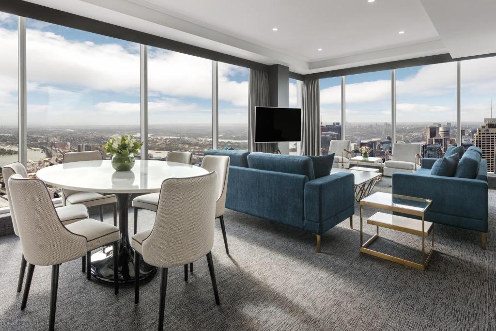 悉尼Meriton Suites World Tower, Sydney的客厅配有蓝色家具和桌椅
