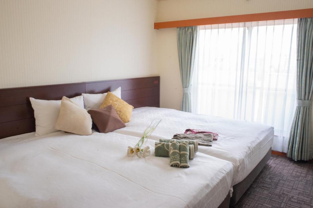 东京Outlet Hotel UenoEkimae的卧室配有带鞋的大型白色床